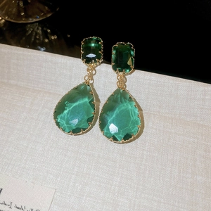 Detail showing the emerald green teardrop gemstone earrings with gold plated frame