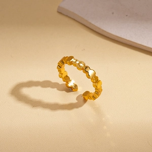 Macro detail of a 24k gold-plated open ring featuring a geometric undulating wave design