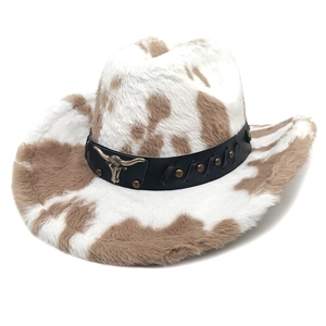 Detail of cow print cowboy hat featuring a leather band with metal bull head ornament