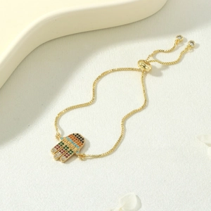 Detail of adjustable gold Hamsa bracelet with MAMA pendant and colorful zircon stones