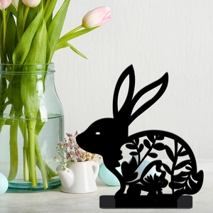 Close-up of black hollow Easter bunny cutout with floral patterns on a festive table