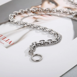 Macro detail of silver double-layer Cuban chain necklace with stylish OT toggle clasp