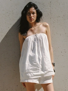 Détails de la texture du haut plissé sans bretelles et du short en coton blanc