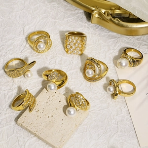 Detailed display of assorted vintage gold rings with pearls on elegant stone decor