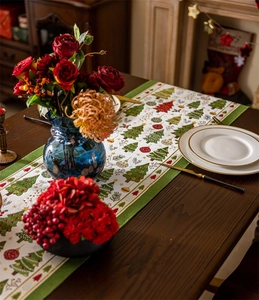Detail of Christmas tree patterned table runner with green stripes on dark wood table