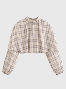 Detail of checkered cropped blouse with high neck and layered poncho style design