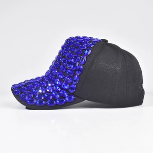 Dettaglio di un cappello da baseball nero con strass blu sulla tesa e sulla corona