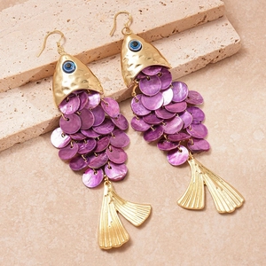 Detail view of gold fish-shaped earrings with purple scales and blue evil eye detail