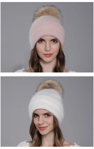 Détail de bonnets tricotés avec pompons en fourrure en coloris rose doux et blanc pur