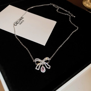 Dettaglio del ciondolo a fiocco d'argento con zircone rosa a goccia su catena a croce