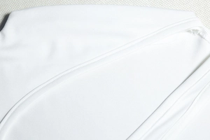 Close-up of fine stitching and ribbed texture on a white bodycon mini dress