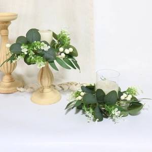 Dettaglio di ghirlande per candele in eucalipto artificiale con bacche bianche decorative