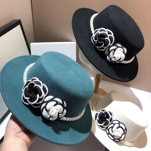 Detail of wool boater hats featuring camellia flowers and pearl bands in various colors
