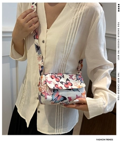 Chic butterfly print shoulder bag in white and pink, shown worn as an elegant underarm bag