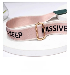 Close-up of pink woven shoulder strap with gold metal buckle and keep massive lettering