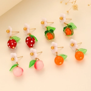 Detail of colorful fruit earrings including strawberry and orange with white floral accents