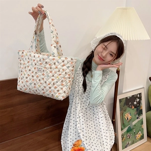Quilted tote bag with cute bear and floral print shown in a cozy home setting