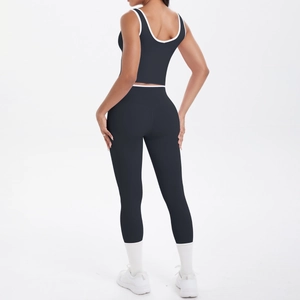 Detail view of the high-waisted back design on black yoga leggings with white piping