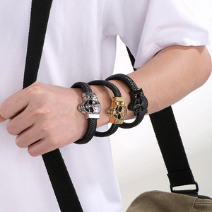 Detail of men's braided leather bracelet with skull metal clasp in three distinct colors