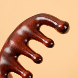 Natural sandalwood scalp massage comb with smooth wood grain on beige background