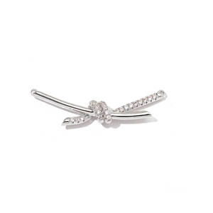 Close-up of silver bow pendant with cubic zirconia and metal connection rings
