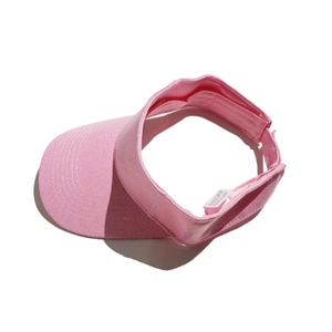 Detail view of pink sun visor hat with interior washing label and quality cotton texture