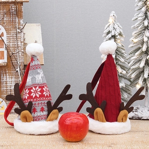 Sacchetti regalo natalizi a maglia con corna di renna e pompon su tavolo di legno