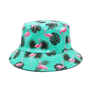 Close-up of pink flamingo and tropical palm leaf print on a teal summer bucket hat