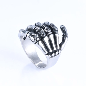 Detail shot of vintage silver skull hand ring featuring intricate bone carvings and punk style