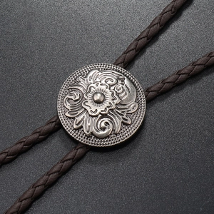 Detailed macro of vintage silver floral buckle and brown braided leather on a Bolo Tie