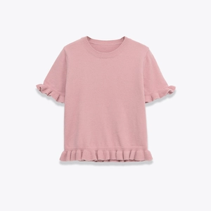 Detail of light pink knit top featuring delicate ruffle trim on sleeves and hemline