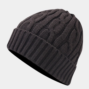 Detailed view of dark grey cable knit pattern and ribbed cuff on a winter beanie hat