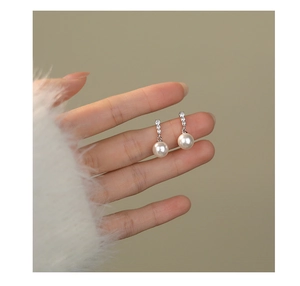 Close-up of elegant S925 silver pearl drop earring with sparkling diamond accents