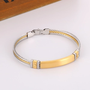 Detail of two-tone braided steel wire bracelet with a golden brushed metal bar