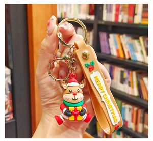 Close-up of a festive PVC reindeer keychain with embossed Merry Christmas silicone strap