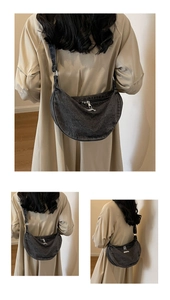 Three-way view of a large charcoal denim crescent bag with silver zipper on a model
