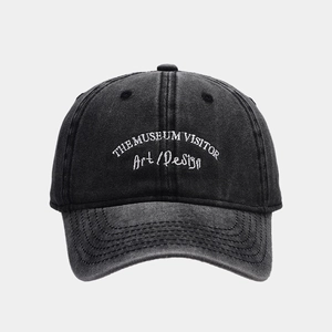 Close-up of white letter embroidery on vintage dark grey washed denim baseball cap