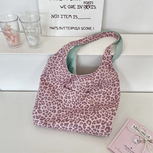 Detail of leopard print suede tote bag with mint green lining and woven label