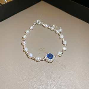 Dettaglio del bracciale con perle barocche e ciondolo a girasole con zaffiro blu