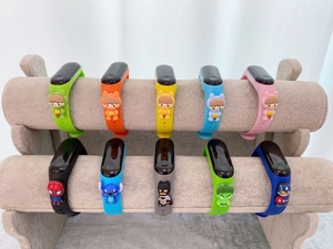 Colorful silicone cartoon wristbands for kids displayed on a velvet jewelry stand