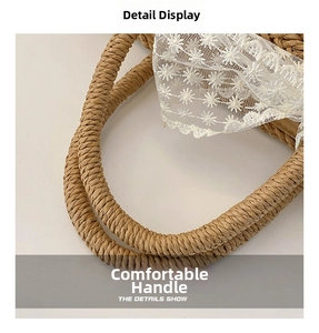 Detail view of the brown straw woven handle and white lace trim on the crossbody bag