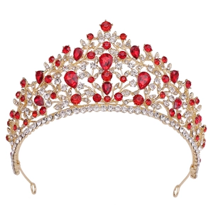 Close-up of golden bridal tiara featuring red teardrop gemstones and white crystals