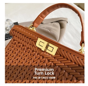 Detail of high-quality golden turn-lock and hand-woven brown leather on stylish handbag