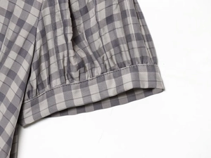 Detail of elastic ruffled cuff on gray plaid dress made of cotton linen fabric