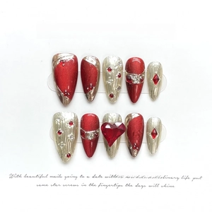 Oxblood red cat eye press-on nails with 3D heart gems and gold embossed details