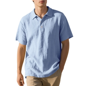 Detail of light blue linen polo shirt showing breathable textured fabric and button collar