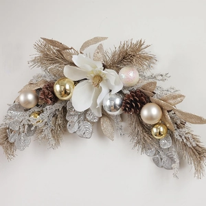 Christmas wreath featuring white magnolia flower with gold and silver ornaments and pine cones