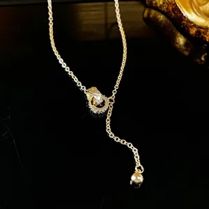 Collier en Y doré élégant avec texture matelassée et anneaux entrelacés en zircone