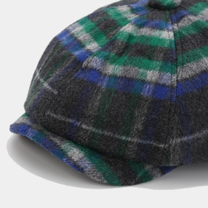 Macro side view of plaid newsboy hat fabric texture in blue green and grey wool