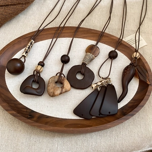 Flat lay of vintage wood resin tassel necklaces in various geometric shapes on a wooden tray